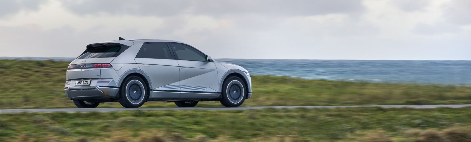 An IONIQ 5 driving along a coastline.